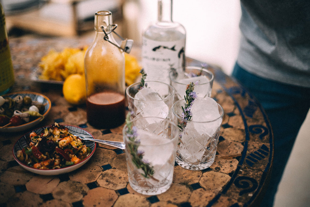 Auf einem Tisch ist Gin und Essen gedeckt